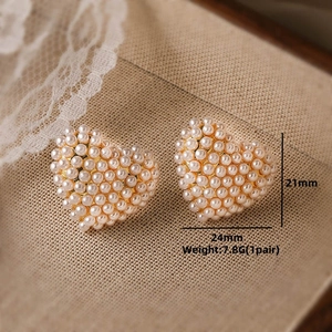 Macro shot of heart-shaped pearl earrings in gold base with size 24mm by 21mm details
