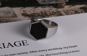 Dettaglio dell'anello a sigillo esagonale in acciaio argento con intarsio in smalto nero