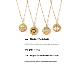 Détail macro de pendentifs oeil porte-bonheur en émail et zircon sur chaîne en acier doré