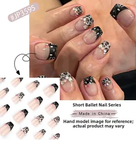 Detail of short ballerina nails featuring leopard print, cat motifs and rhinestones