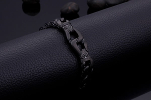 Macro shot of vintage black stainless steel fist link chain bracelet on leather display