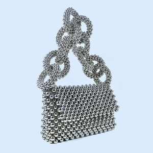 Close-up of luxury handcrafted silver beaded clutch featuring unique metal ring handles