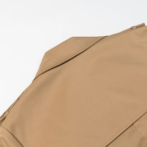 Close-up of khaki trench coat showing premium twill fabric texture and fine stitching details