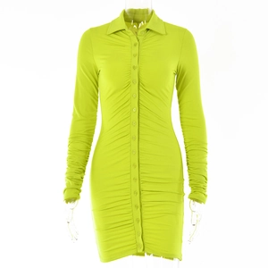 Detail of neon green long sleeve mini dress with button closure and ruched fabric texture