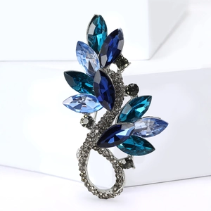 Detail of elegant silver leaf brooch with blue marquise crystals and grey rhinestones