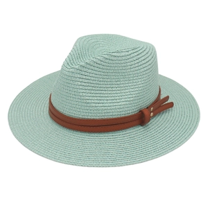 Detail of mint green straw fedora featuring a brown faux leather band and metal rivets