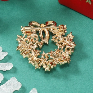 Detailed back view of a gold Christmas wreath brooch with a secure safety pin clasp