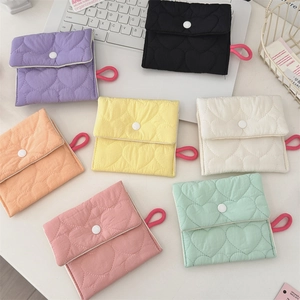 Detailed flat lay of quilted heart-pattern mini organizers in seven vibrant candy colors
