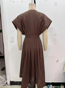 Détail de la robe midi plissée marron montrant la taille froncée et la texture plissée