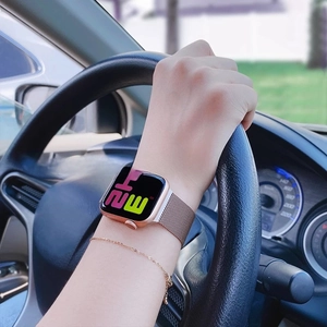 Rose gold Milanese loop metal strap on a smartwatch shown during a driving scene