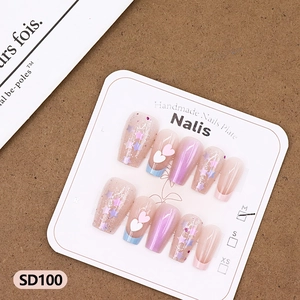 Macro detail of handmade heart and star press-on nails with sparkling pink glitter finish