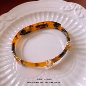 Vintage tortoiseshell open bangle with gold star accents on elegant white ceramic plate