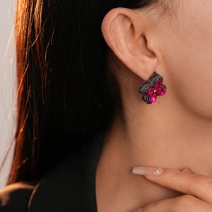 Vintage rhodium flower earrings with vibrant magenta gemstones on a fashion model