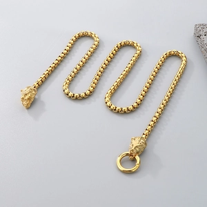 Nahaufnahme der goldenen Löwenkopf-Verschlüsse und des Rings an der Vierkantperlenkette