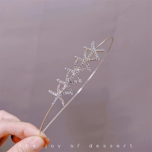 Detail of elegant gold headband with five crystal-encrusted starfish charms