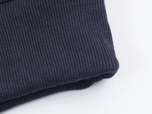 Close-up of dark blue ribbed knit fabric showing detailed texture on sleeve cuff or hem