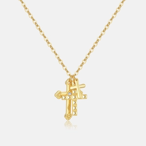 Detail of gold triple-layered cross necklace with studded, polished, and zircon accents
