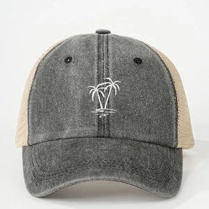 Détail de la broderie cocotier blanc sur une casquette trucker grise vintage en mesh