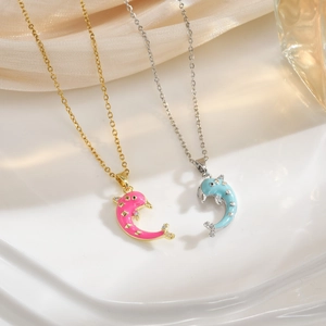 Macro detail of paired dolphin pendants with enamel finish and inlaid zircon stones