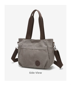 Macro detail of canvas tote side pocket with brown strap and vintage metal hardware