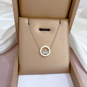 Detailed macro of a silver crown necklace with Lucky engraving inside a gold jewelry box