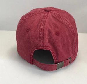 Close-up of the adjustable metal buckle on a vintage washed red baseball cap