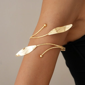 Detailed view of the gold spiral arm cuff featuring textured leaf design on upper arm