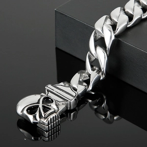 Detail of silver stainless steel curb chain bracelet with a 3D skull clasp mechanism