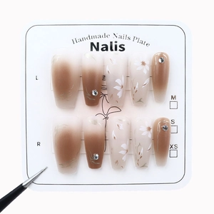 Brown gradient press-on nails with hand-painted white flowers and sparkling rhinestones