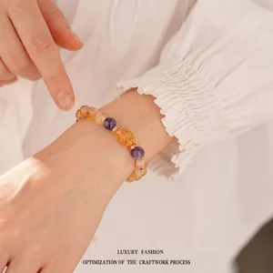 Elegant yellow crystal beaded bracelet with purple amethyst accents on a model's wrist