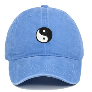 Detailed close-up of Tai Chi embroidery on a light blue washed denim baseball cap
