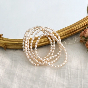 Baroque freshwater pearl bracelet styled with vintage mirror and roses on white silk