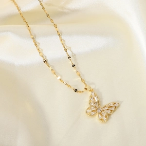Detail of 18K gold butterfly pendant necklace with sparkling cubic zirconia on silk cloth