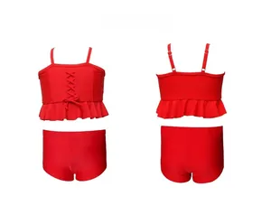 Detailed view of red two-piece girls' swimwear with ruffled hem and adjustable straps