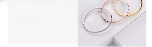 Detailed view of three minimalist geometric bangles in silver, gold, and rose gold finish