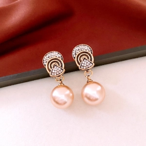 Detail of vintage gold earrings with sparkling crystals and large champagne pearls