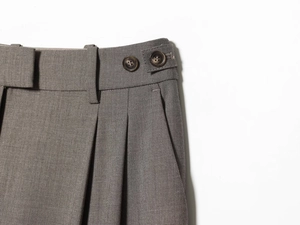 Macro detail of charcoal dress pants waist with side adjusters and woven texture