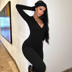 Close-up of black ribbed fabric jumpsuit showing the slim fit V-neck and soft texture