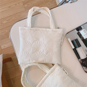 Dettaglio della borsa trapuntata bianca con ricamo a conchiglia ed etichetta simple wish