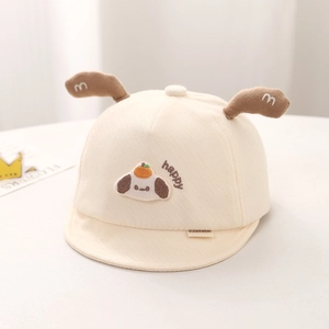 Détail de la casquette bébé en coton avec oreilles de chiot et broderie happy sur tissu