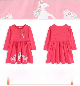 Detail of pink polka dot girl's dress with unicorn and floral embroidery accents