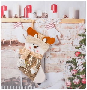 Detailed view of a golden sequin reindeer Christmas stocking hanging on a cozy fireplace