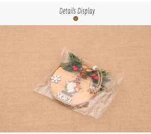 Detail view of round wooden Noel ornament with pine needles and gnome in packaging