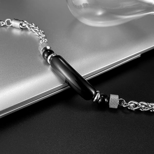 Detailed close-up of a men's stainless steel wheat chain bracelet with tiger eye stone