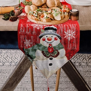 Red Christmas table runner with snowman embroidery and Let It Snow text on wooden table