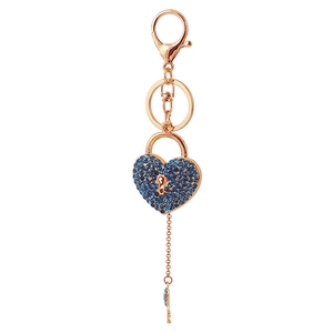 Rose gold heart lock keychain with blue rhinestones and small key charm on white backdrop