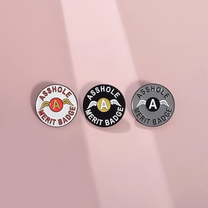 Trois pin's ronds en émail avec ailes en couleurs noir, blanc et gris