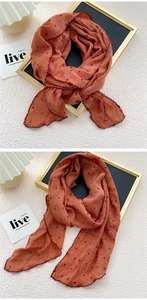Close-up of brick red polka dot scarf featuring delicate scalloped crochet edges and texture