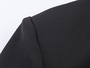 Close-up of premium black twill fabric and shoulder stitching on a fashion blazer