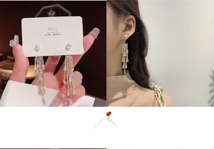 Detailed view of elegant silver tassel earrings with pearls and rhinestones on a model